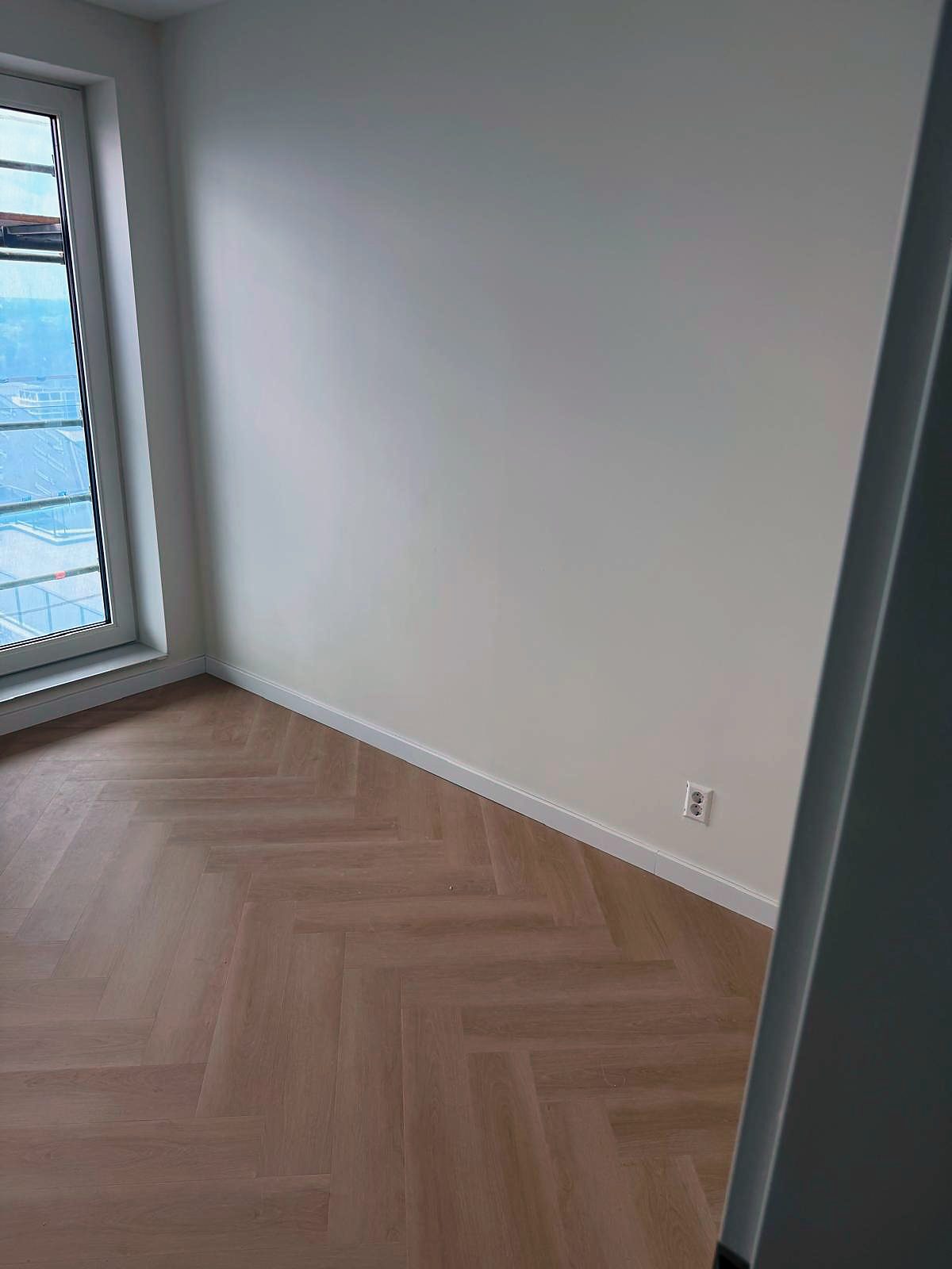 Opgeleverde kamer met visgraatvloer, gladde wanden en strak afgewerkte plinten