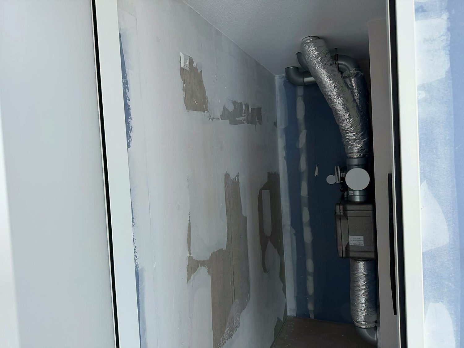 Technische kast met een mechanische ventilatie-unit en geïsoleerde luchtkanalen, ingebouwd tijdens de renovatie